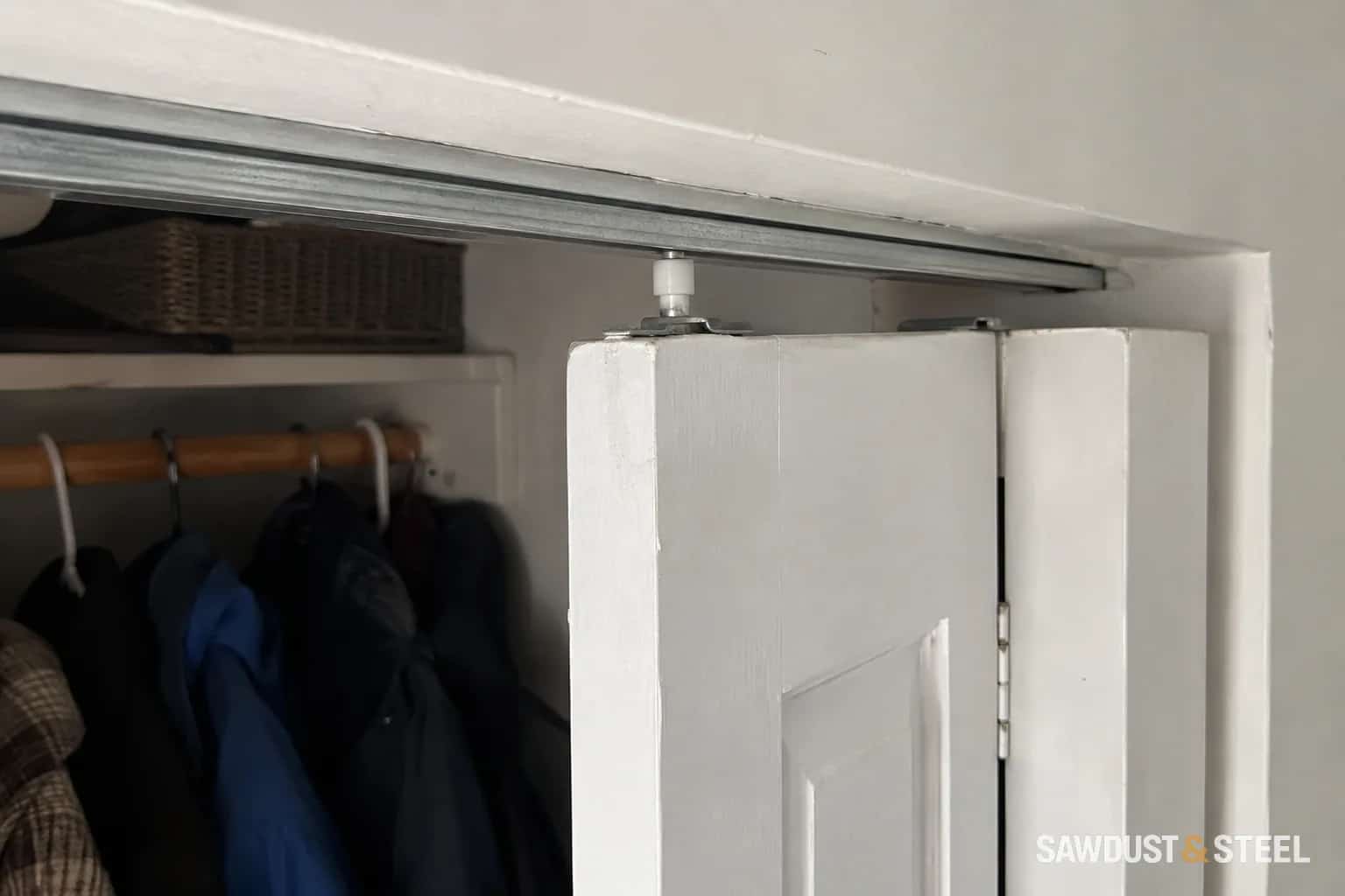 Top guide and track above a bifold closet door