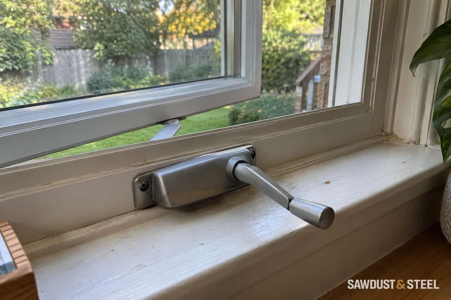 Crank operator at the sill of a partly open white window