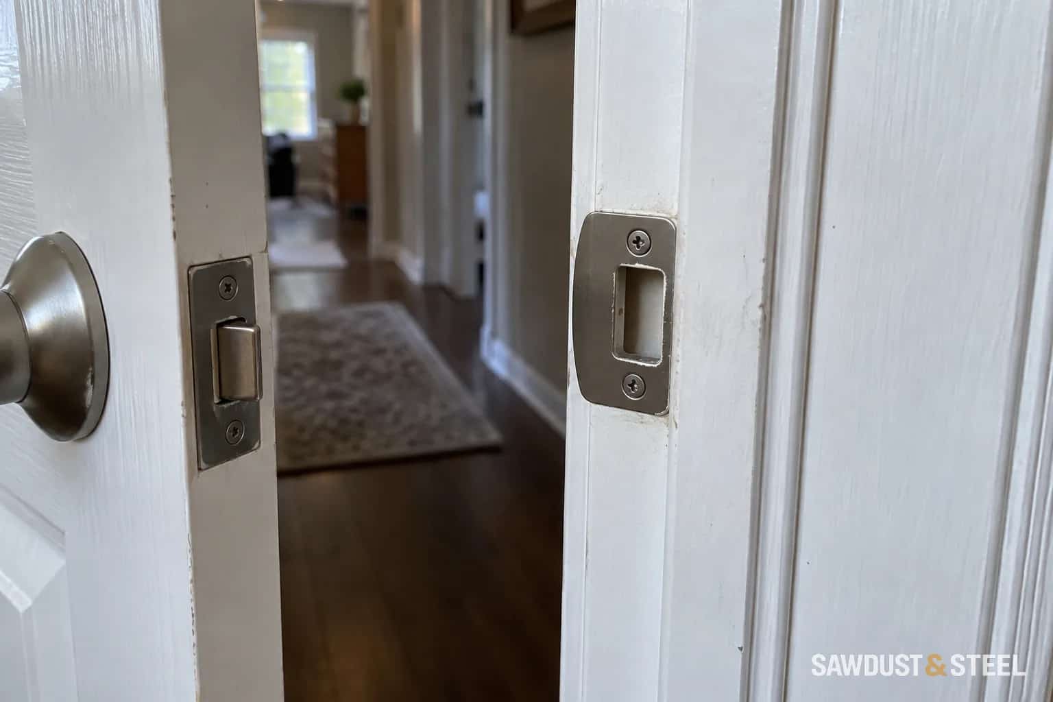 Interior door latch and strike plate in a painted jamb