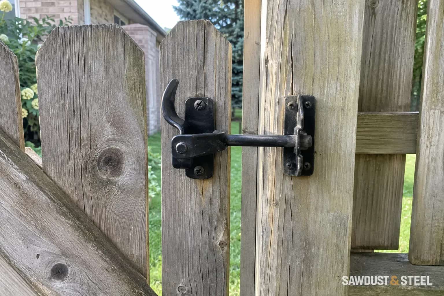 Black latch and receiver on a weathered wooden garden gate and post