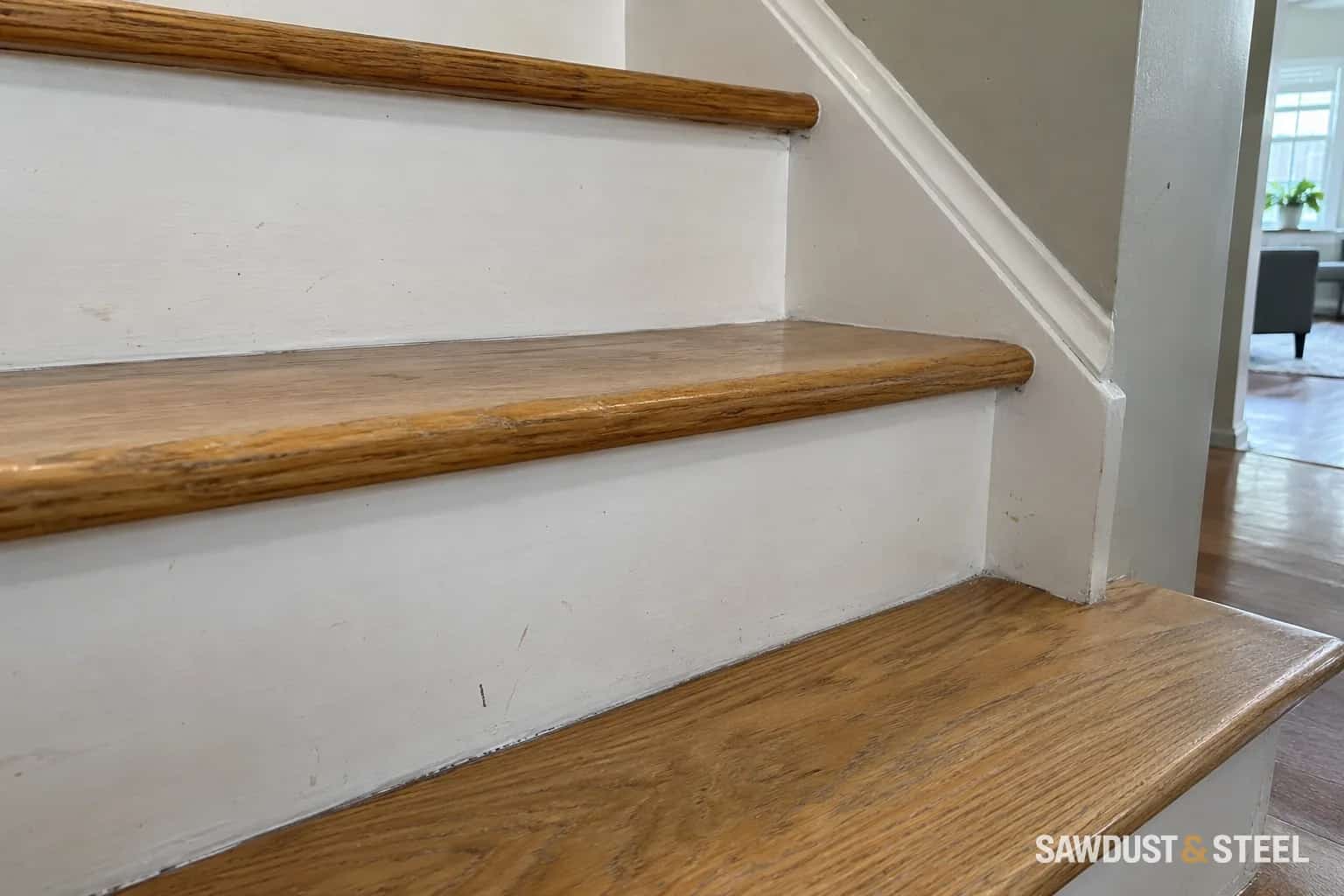 Worn oak stair treads and rounded nosings above white risers