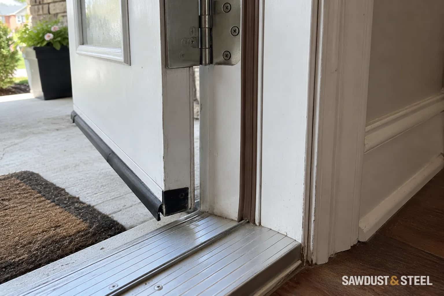 Weatherstrip at an exterior door jamb and aluminum sill