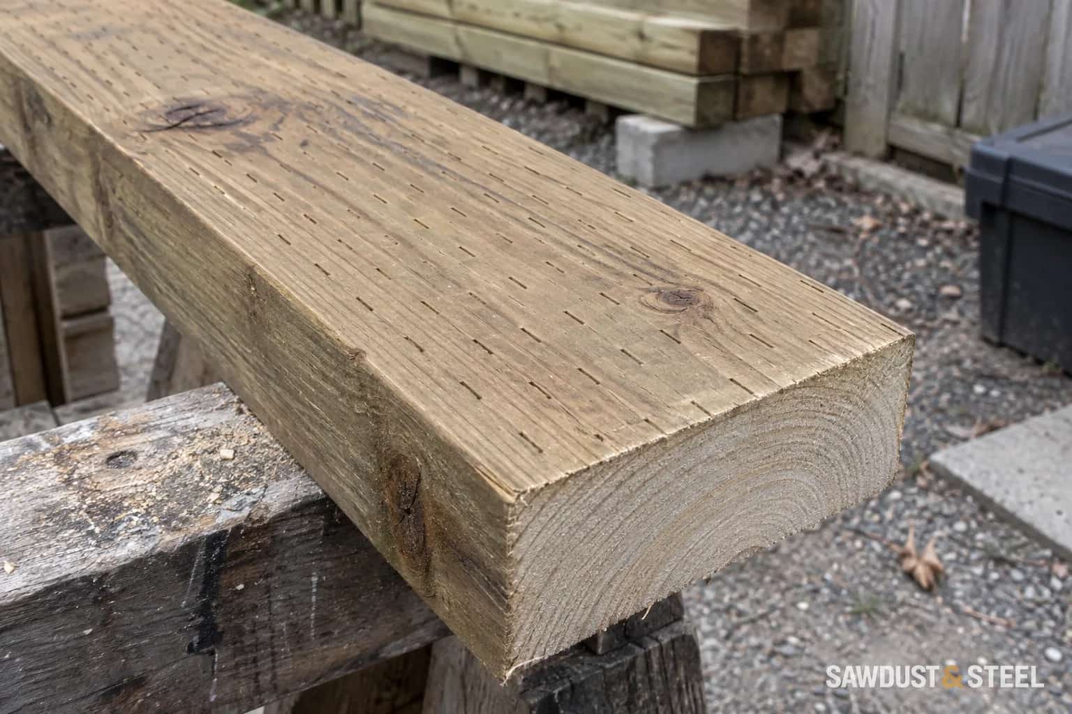 Regular narrow incisions on treated lumber beside its freshly sawn end
