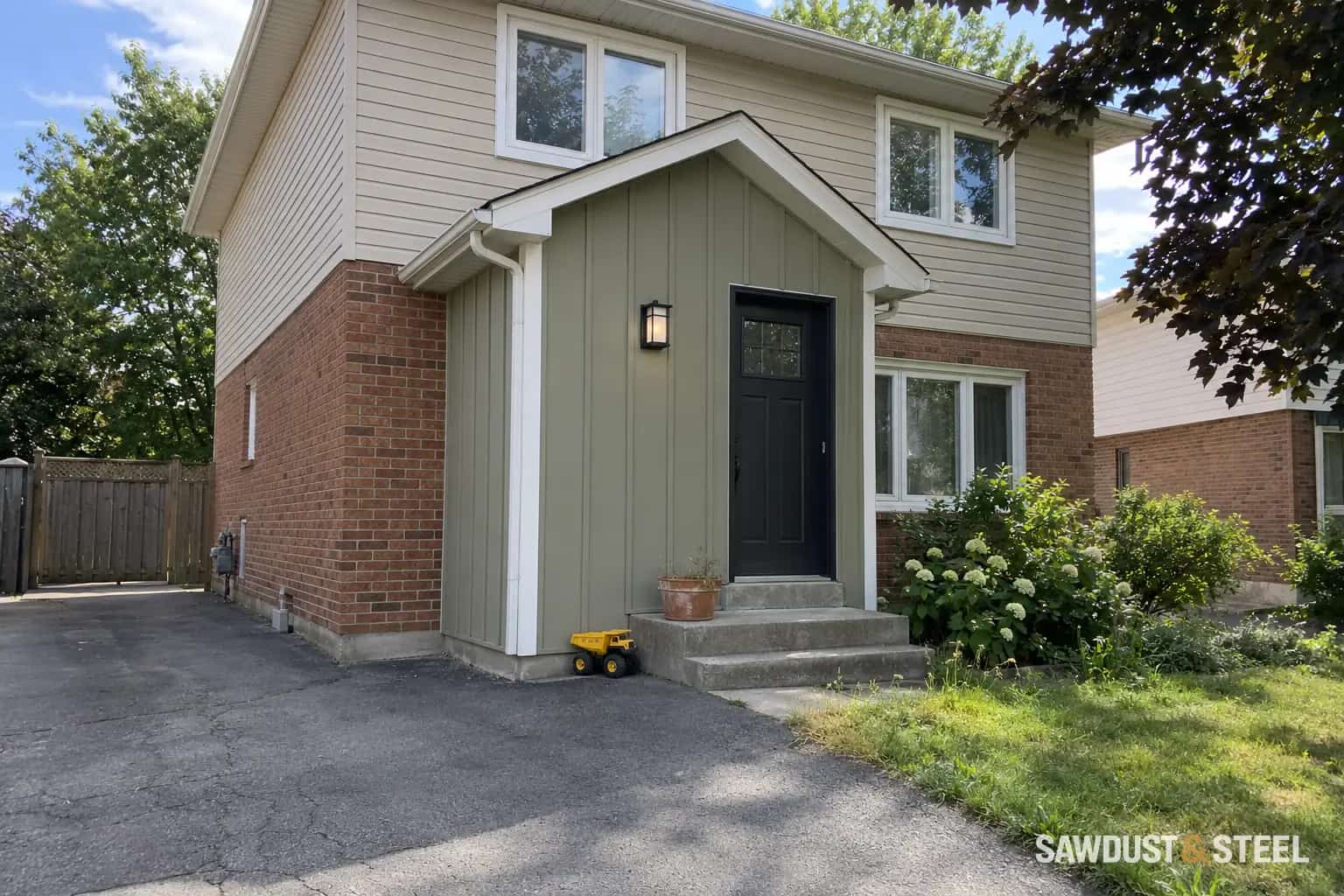 Sage vertical siding on a projecting entry beside brick and horizontal siding