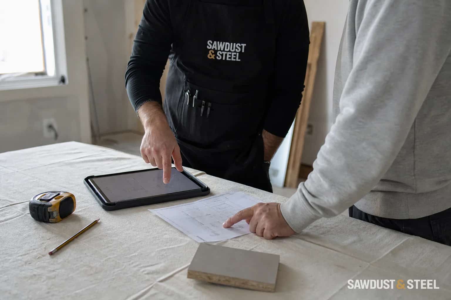 Homeowner and renovator reviewing a written change order beside an open wall