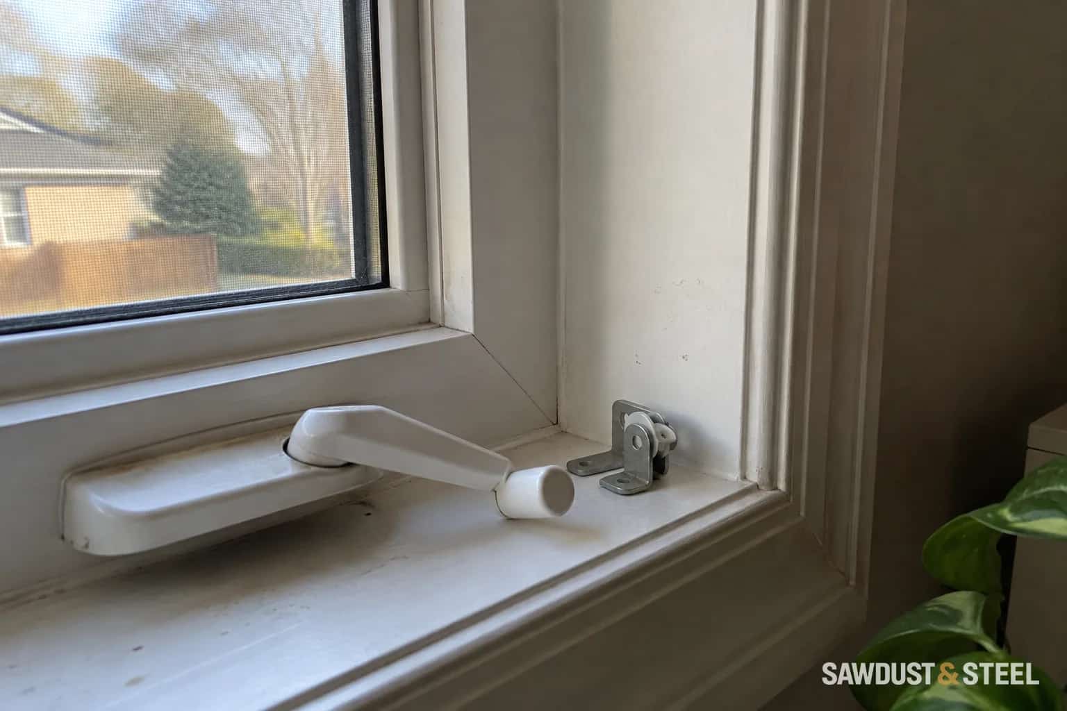 White casement window crank, sill and interior jamb viewed from inside.