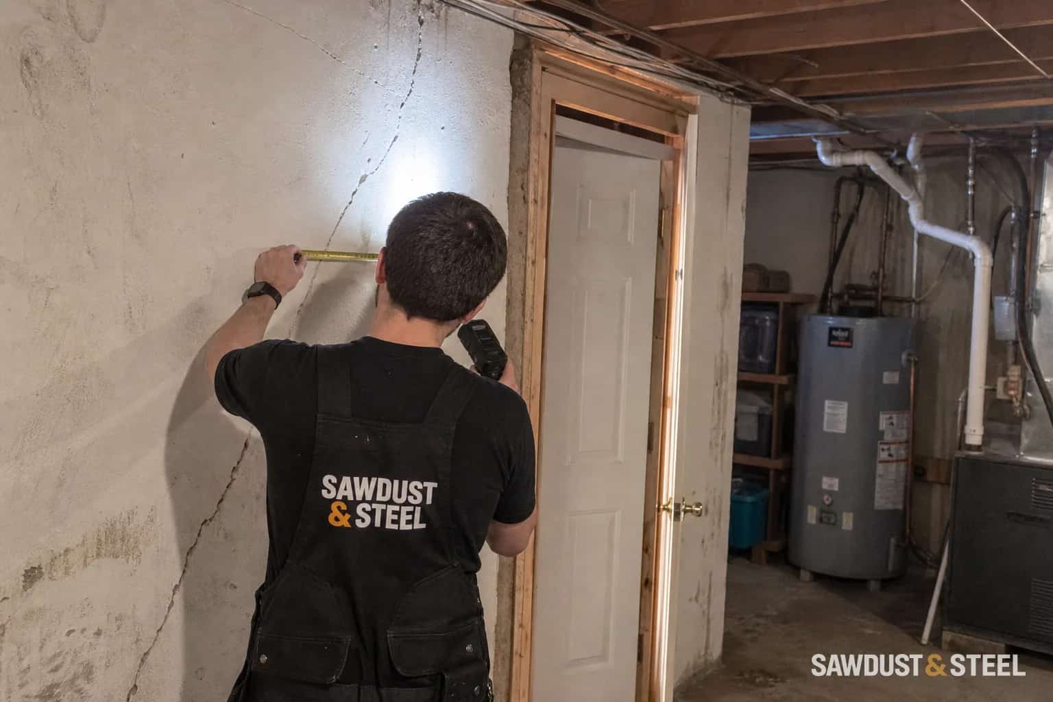 Diagonal crack in a basement wall being measured