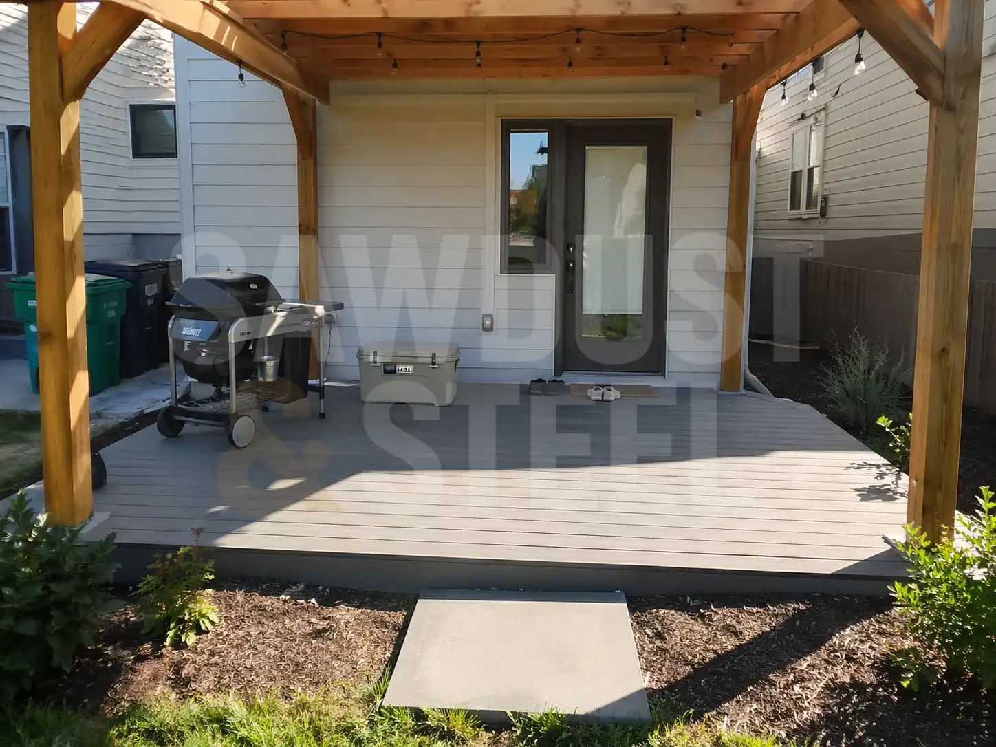 Grey composite deck with a cedar pergola and a grill station