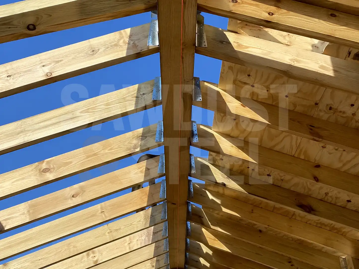Roof rafters and ridge beam with metal brackets on a new second storey