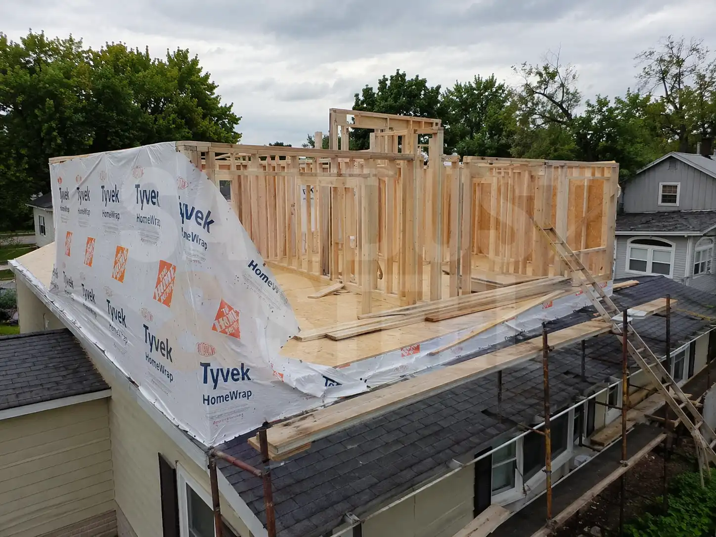 Second storey addition in progress showing new wall framing over an existing bungalow