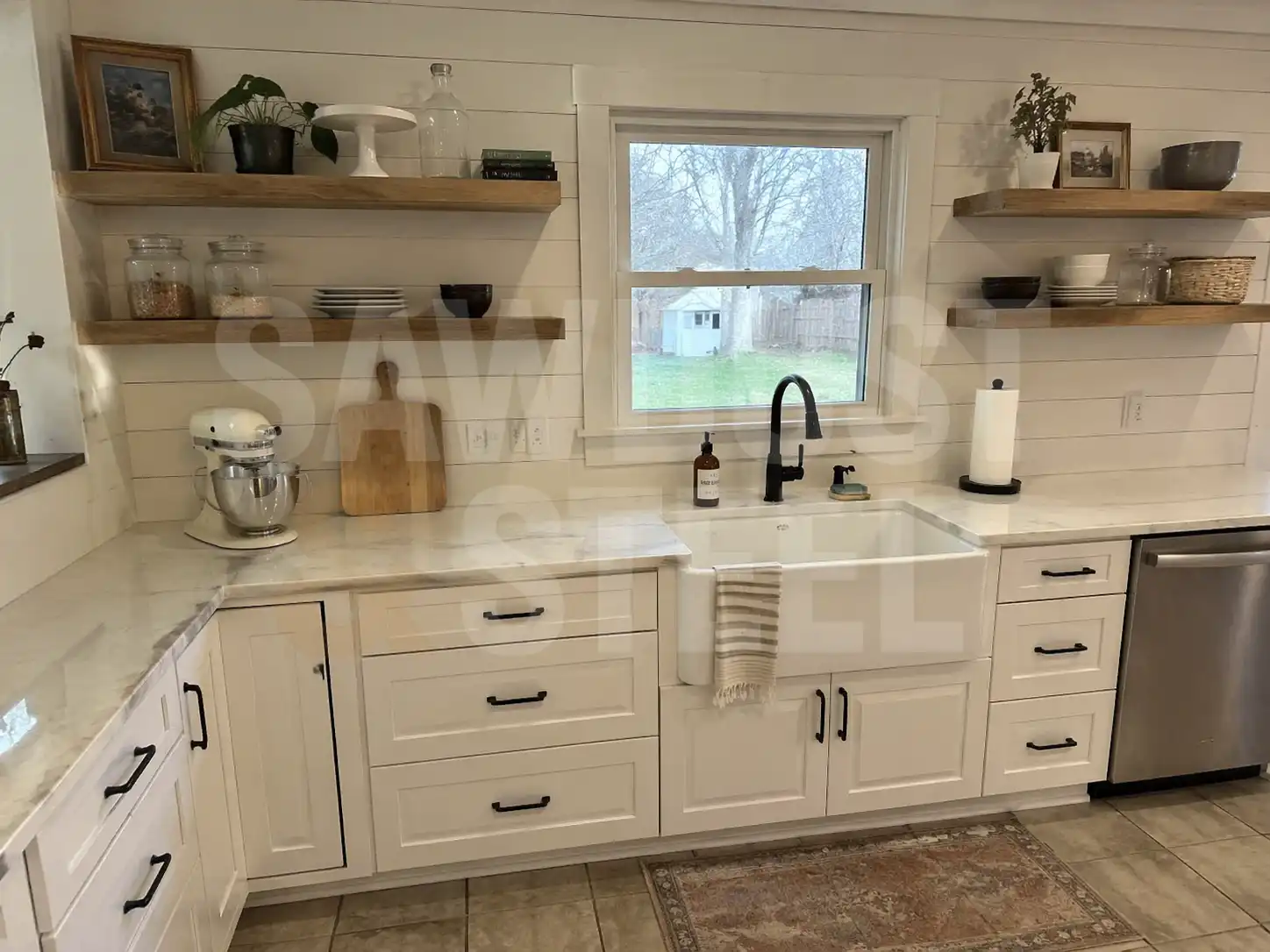 Farmhouse sink with open wood shelves and warm pendant lighting