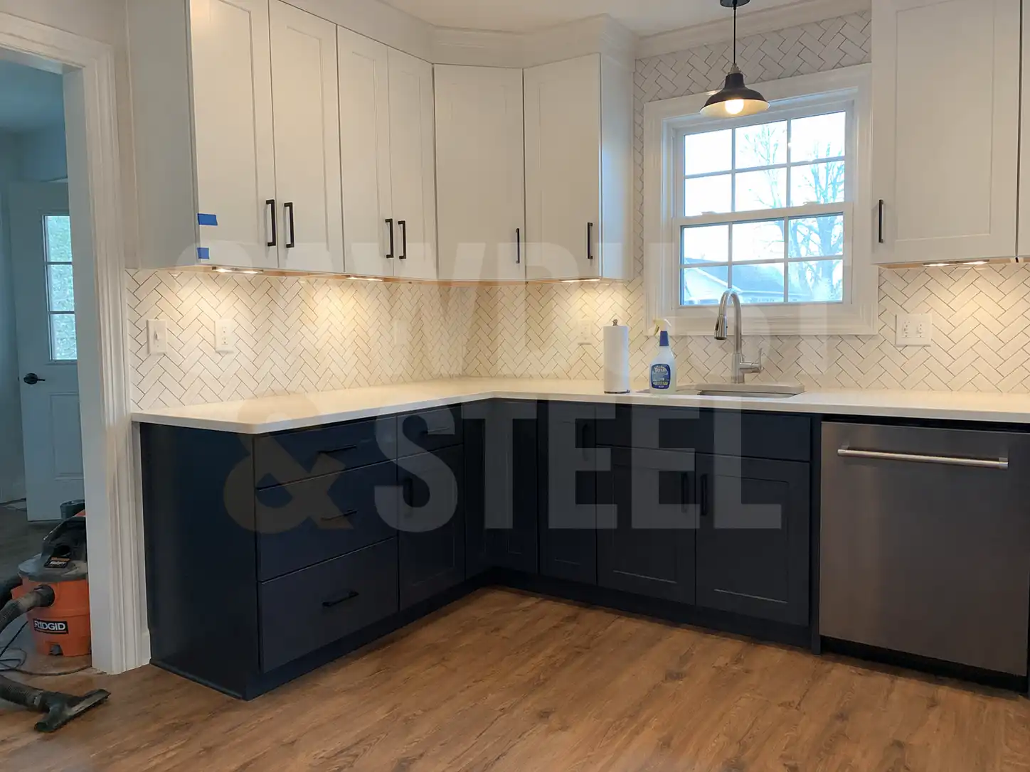 Navy and white kitchen with herringbone backsplash and brass fixtures