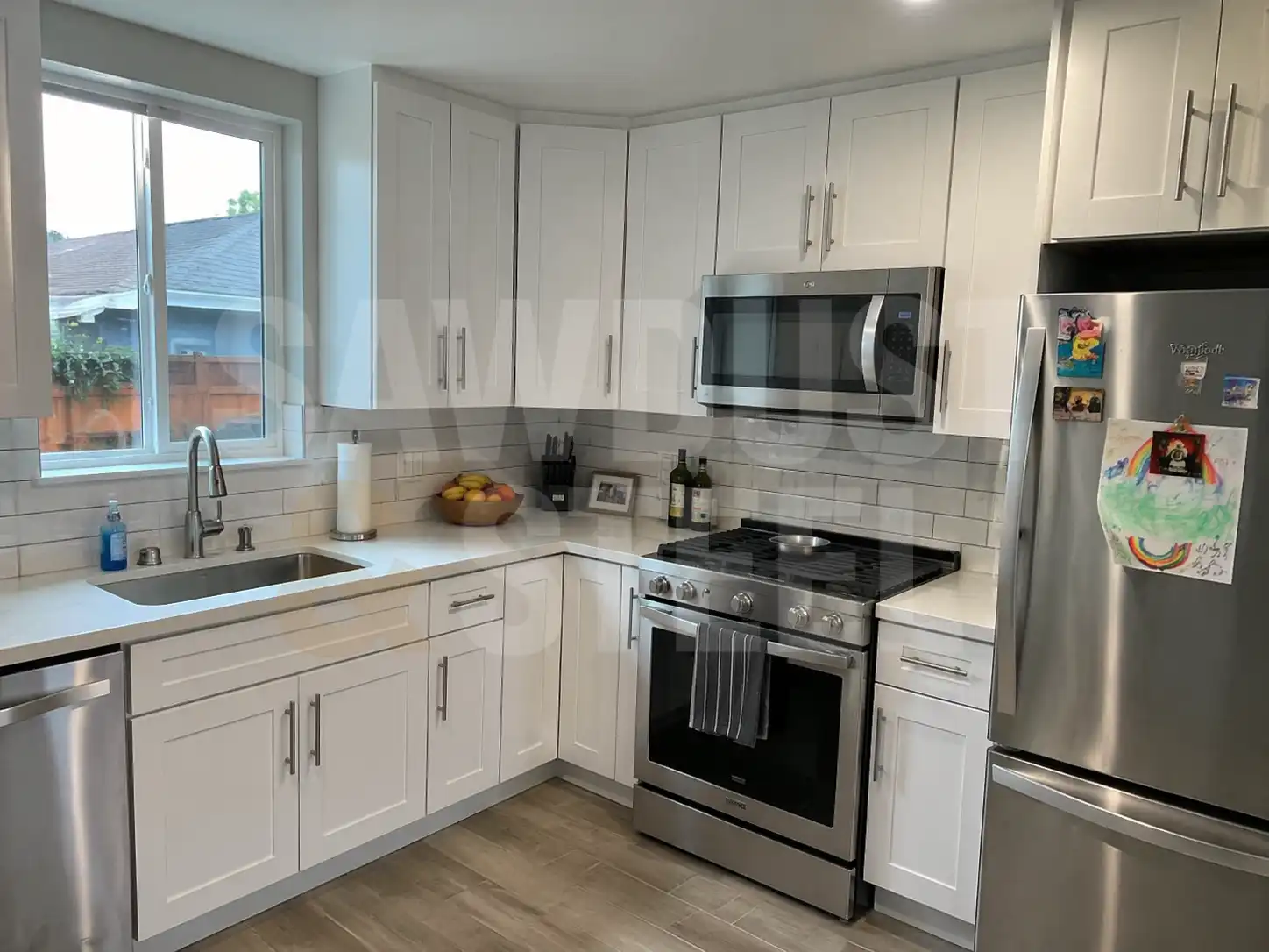 Detail of white shaker cabinets with stainless appliances