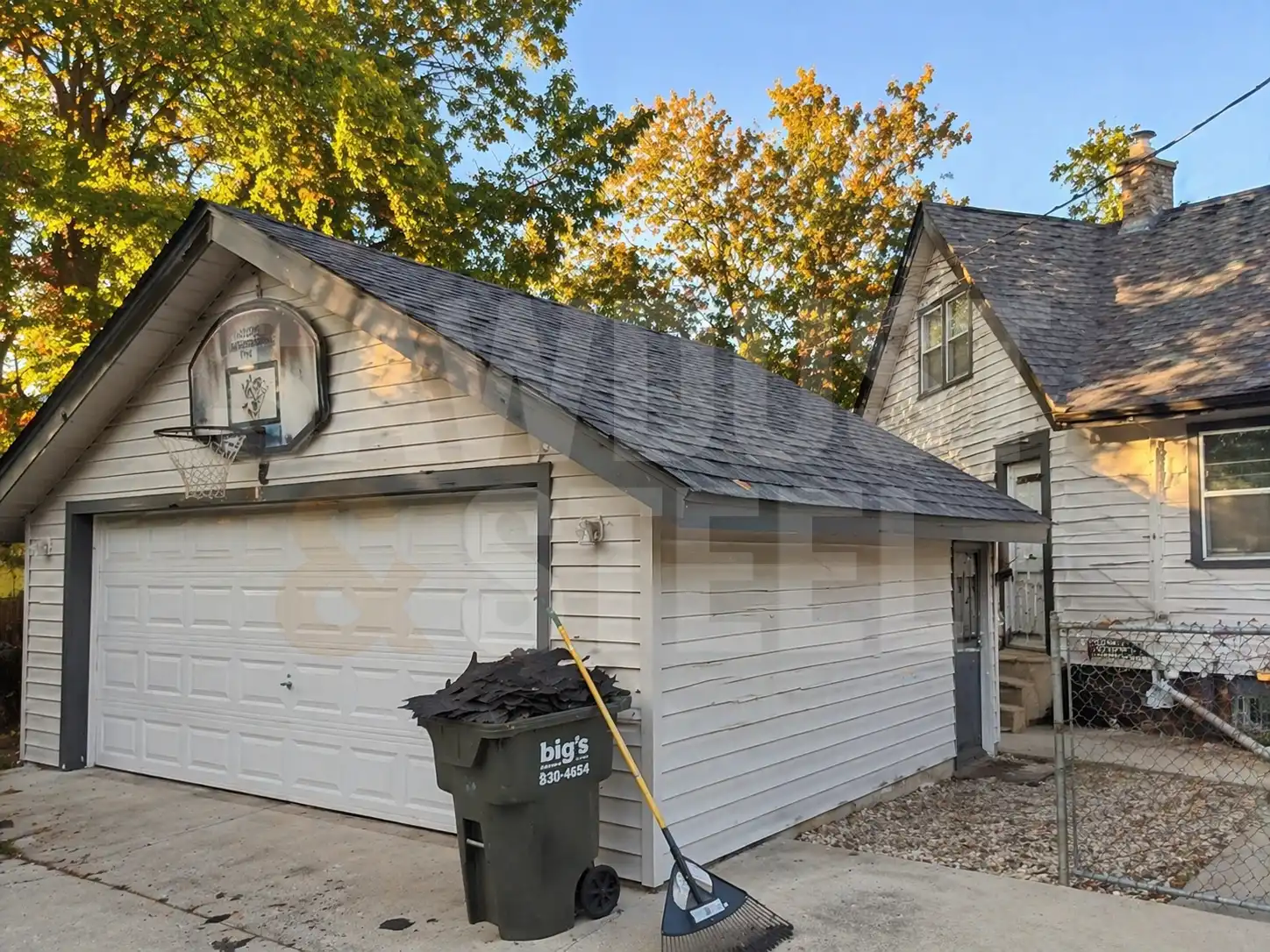 Garage roof tear-off cleanup in autumn with old shingles bagged and ready for disposal