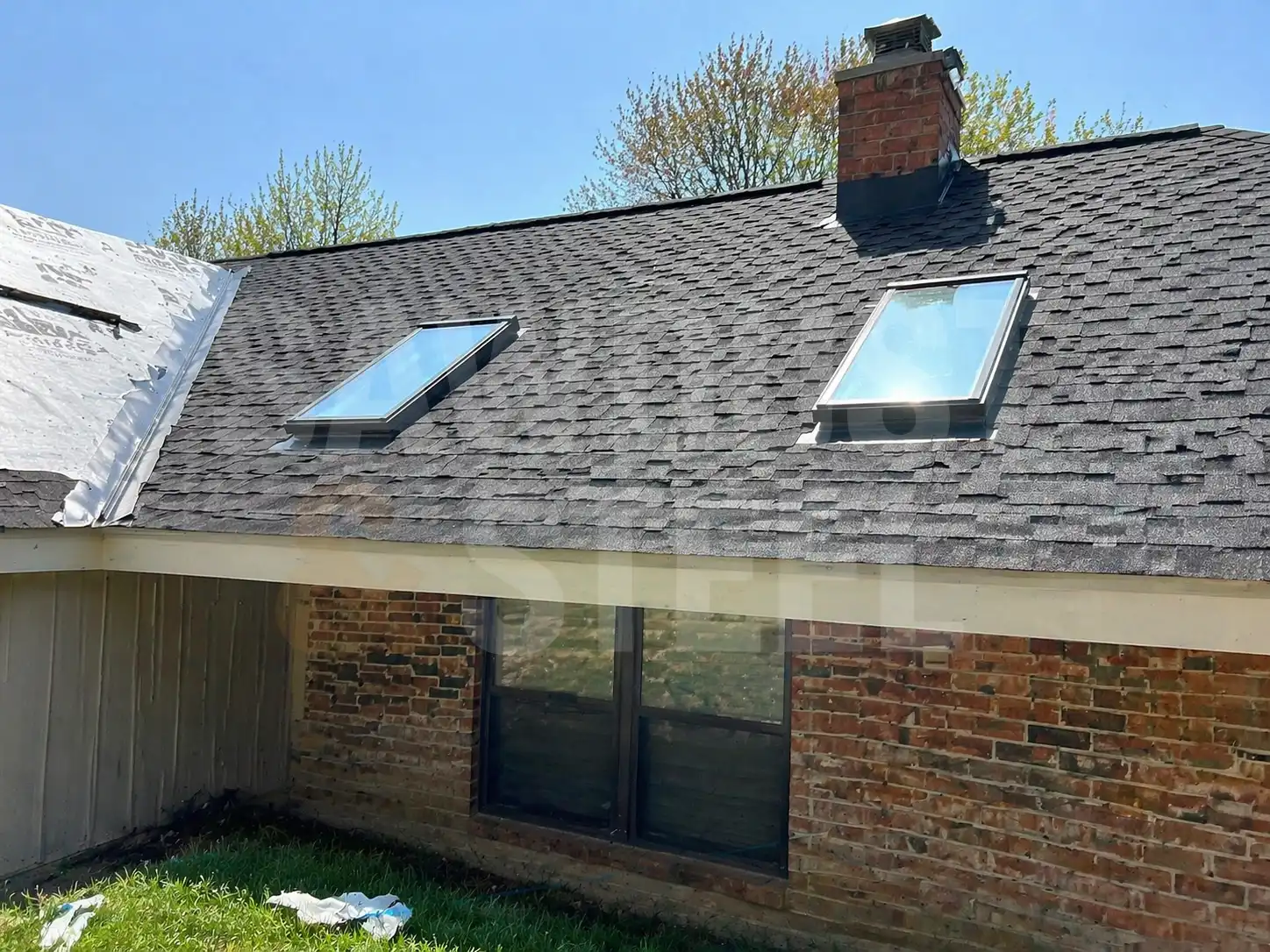 shingle roof with skylights and brick chimney