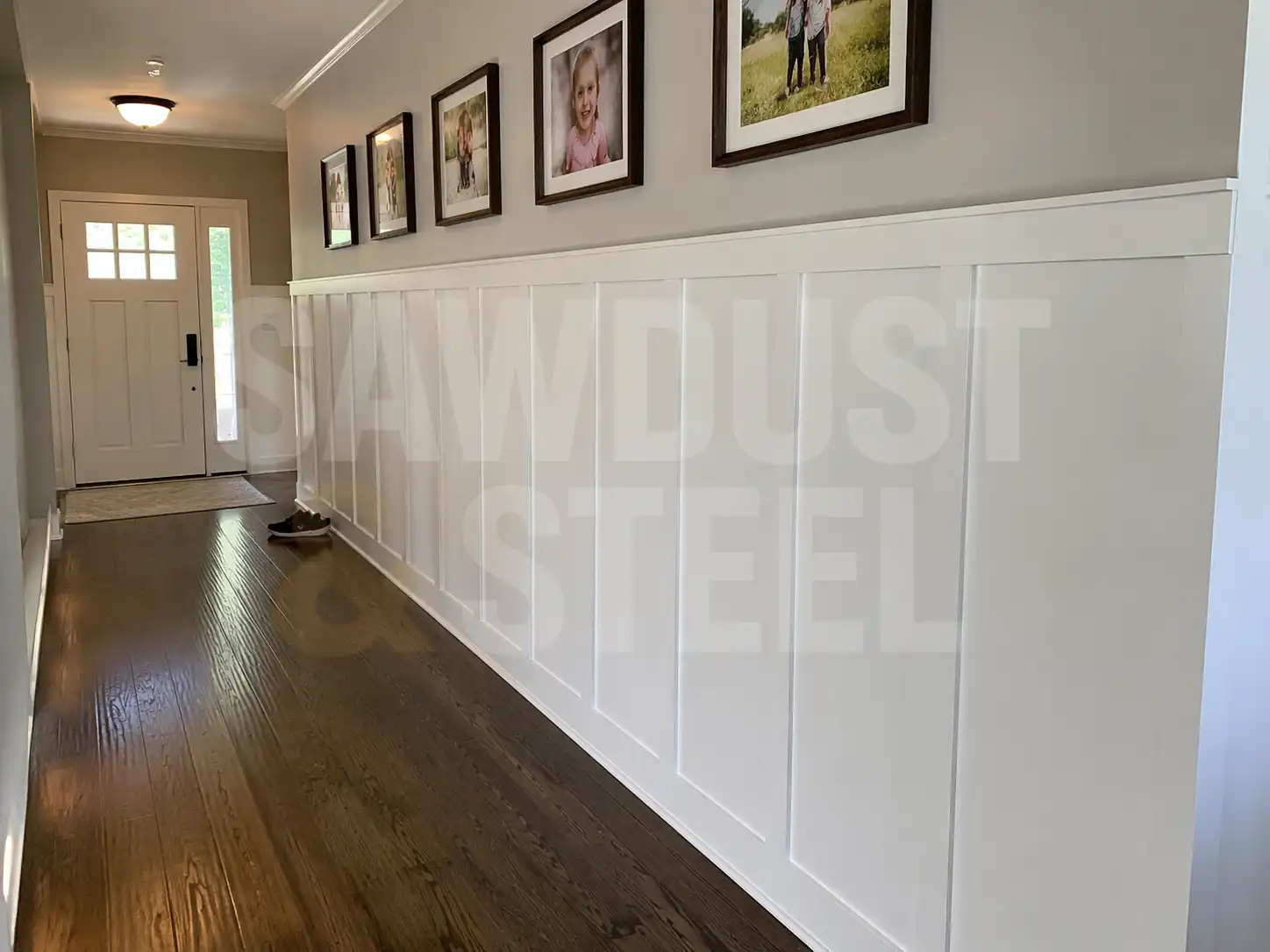 White wainscoting in a hallway over dark hardwood floors